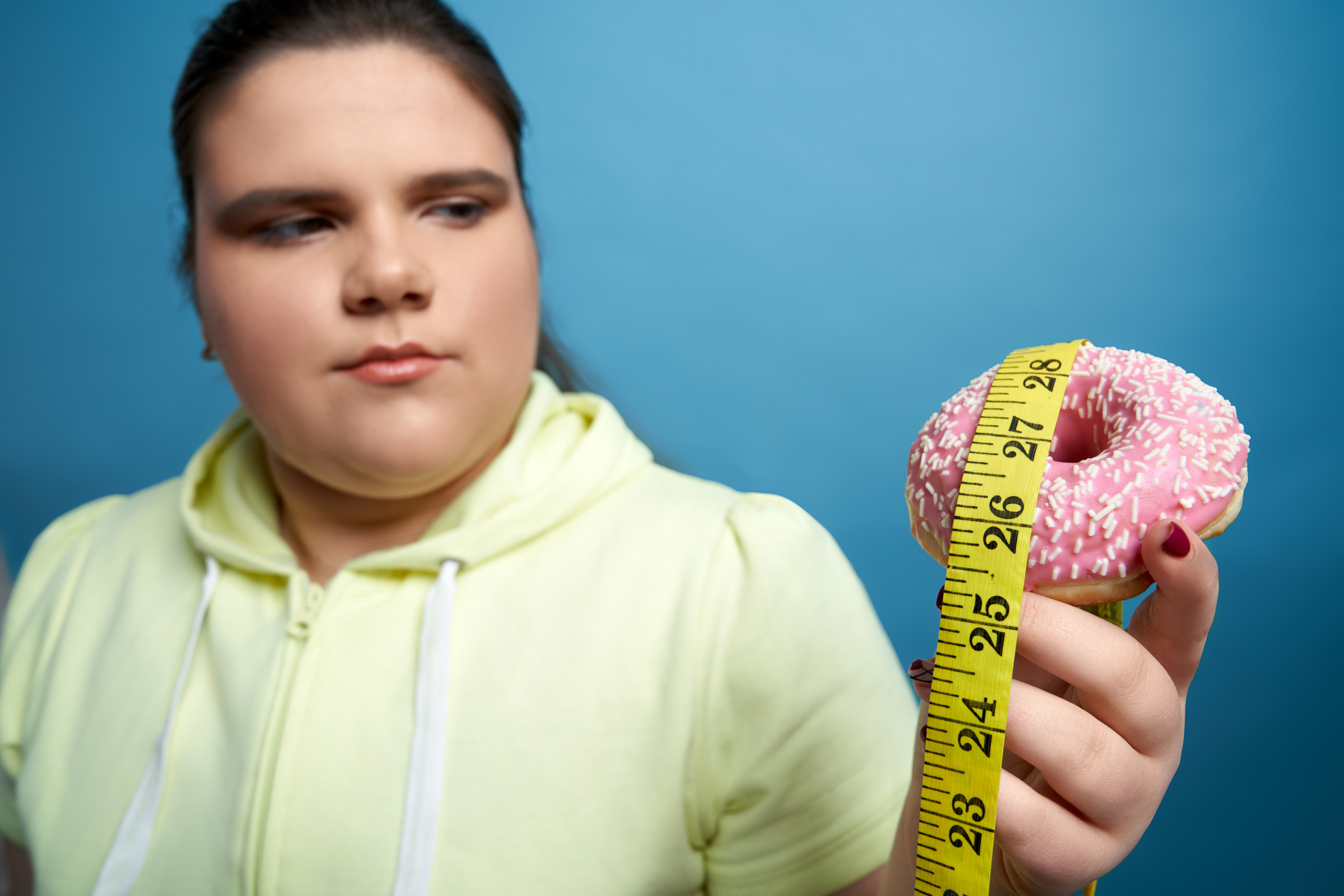 close up of womans hand holding donut with measuri 2025 03 25 08 01 43 utc